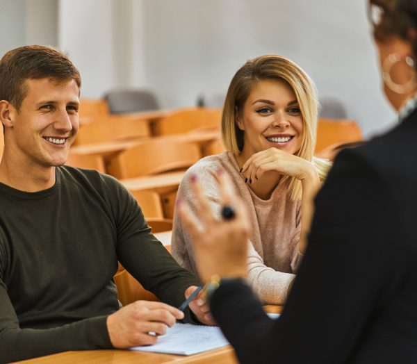 Smiling students and lecturer in auditorium at university