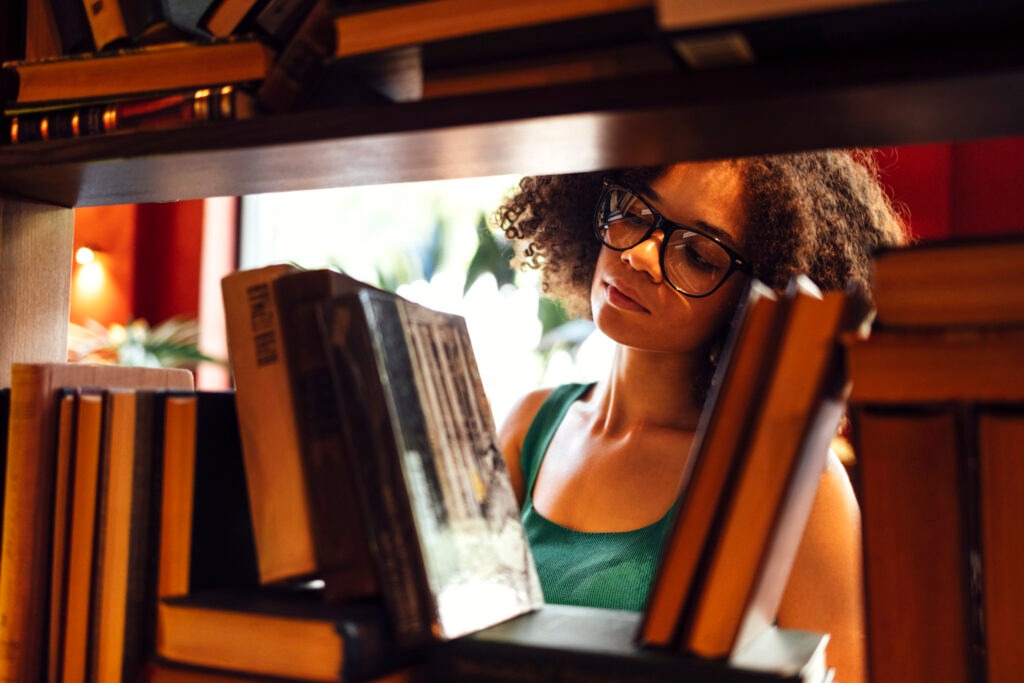 Happy African American female student studing in university library