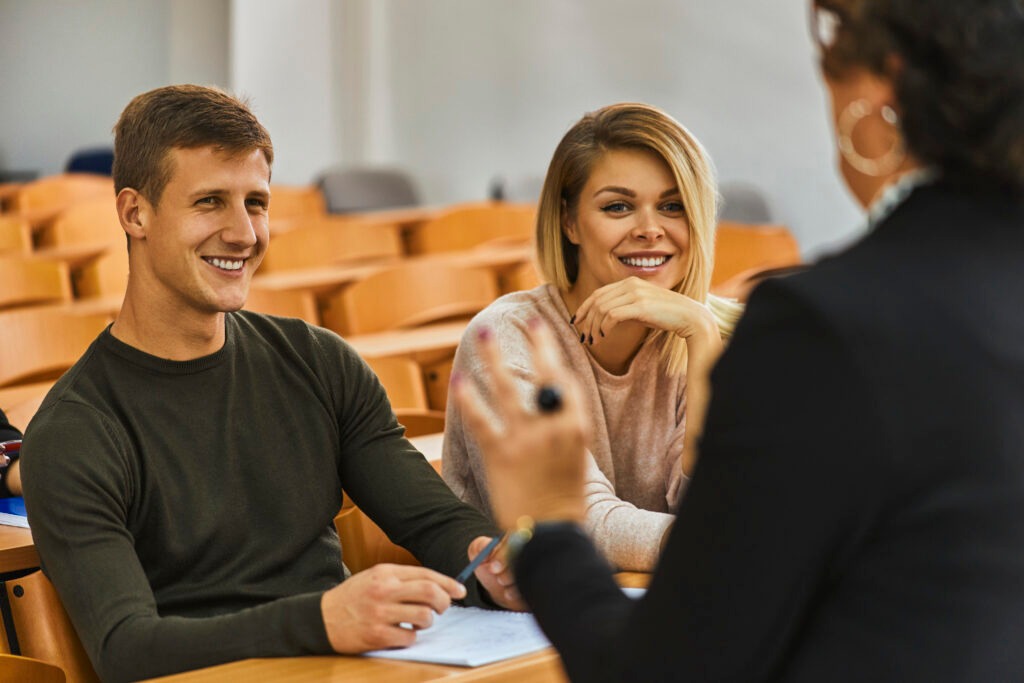 Smiling students and lecturer in auditorium at university