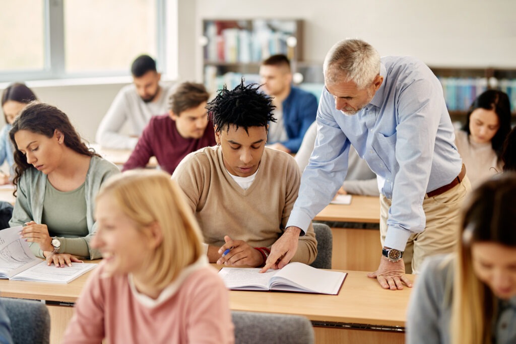 Young black student learning with teacher's help during a class at the university.