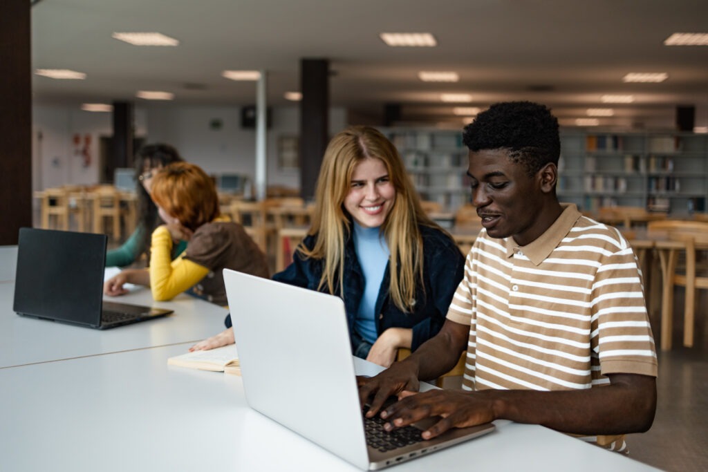 Young people studying together in university library - School education concept