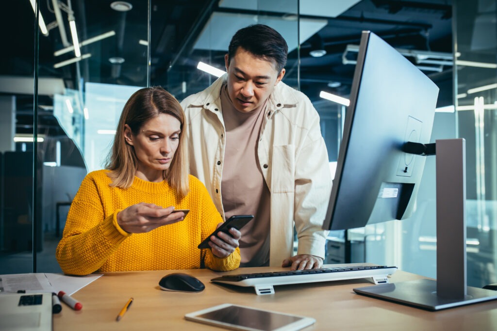 Asian man and woman, employees make a bank transfer using the phone application