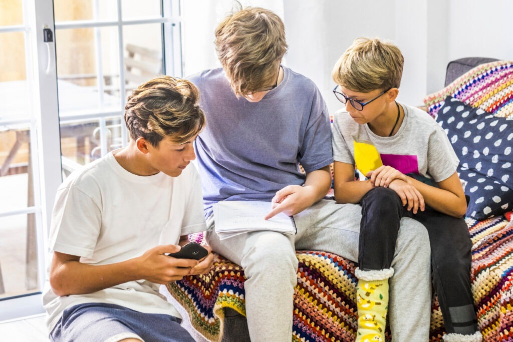 group of teenager looking at book and reading - teenager teaching something at his friends