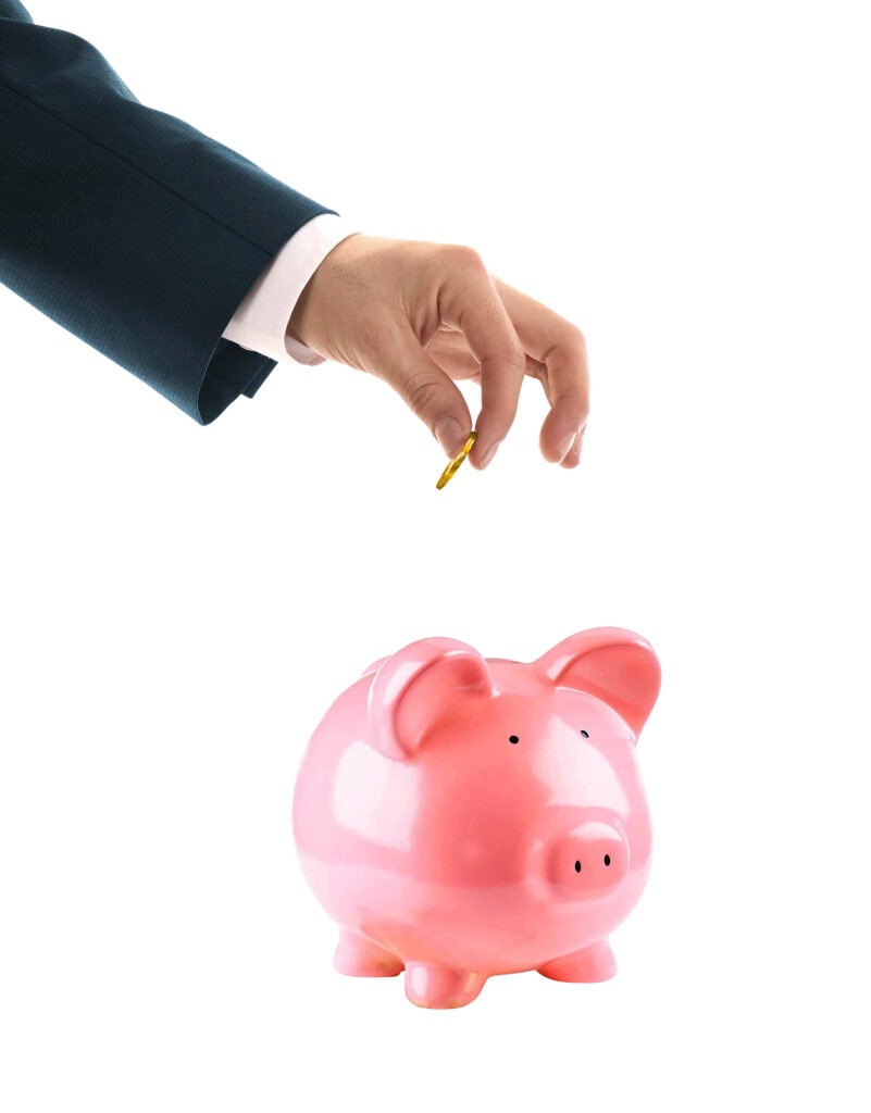 Piggy bank and hand with coin isolated