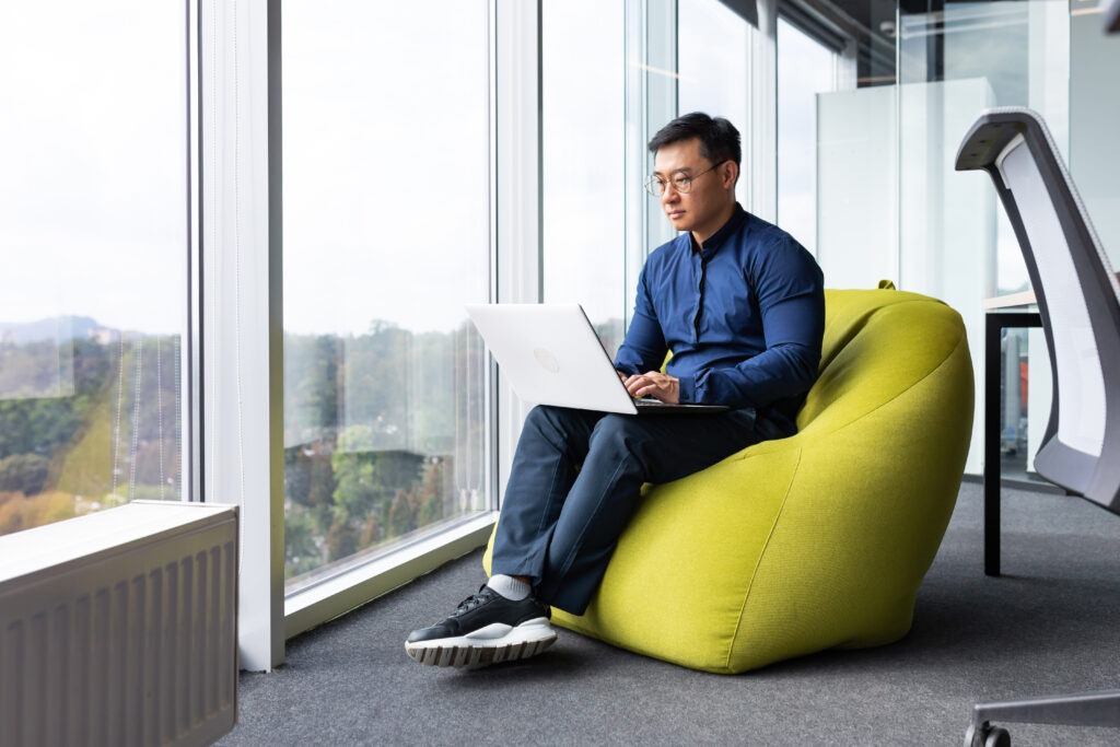 Serious and focused engineer developer programmer writing code using laptop at work to create