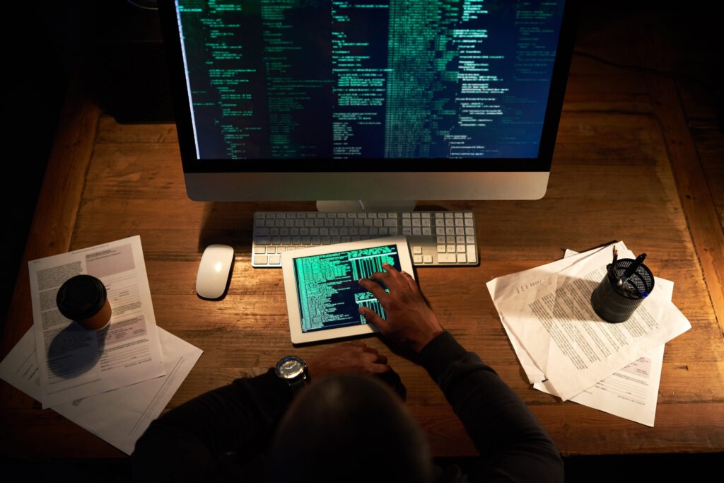High angle shot of an unrecognizable man coding on his tablet in the office