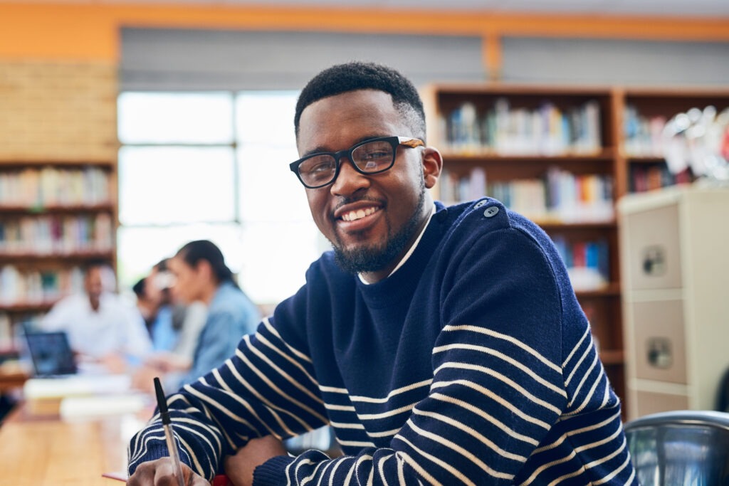 Im working hard for those grades. Portrait of a university student sitting in the library.