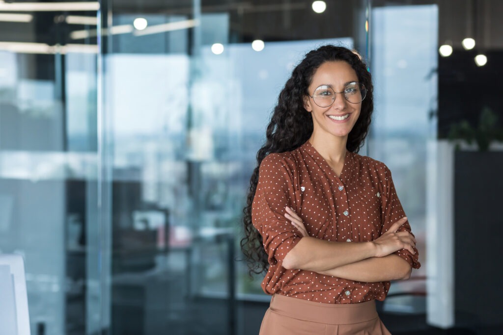 Portrait of Hispanic woman. Curly Latin American student stands in the hall of the university