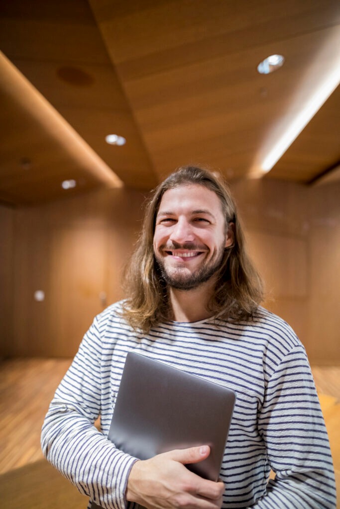 Portrait of laughing man with laptop in university