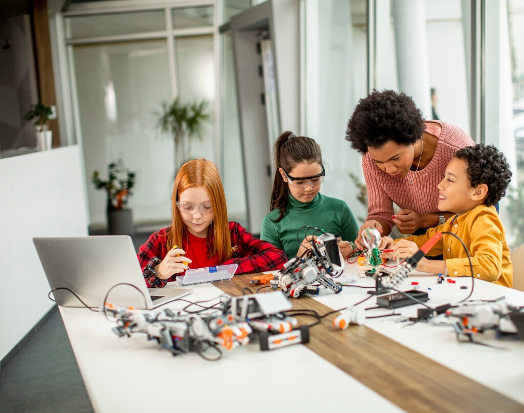 kids with their African American female science teacher with laptop