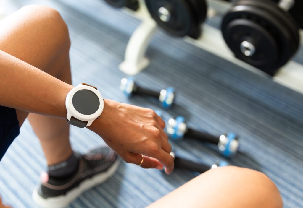 Using a smart watch at the gym, tracking calories and steps; weight lifting; health and wellness