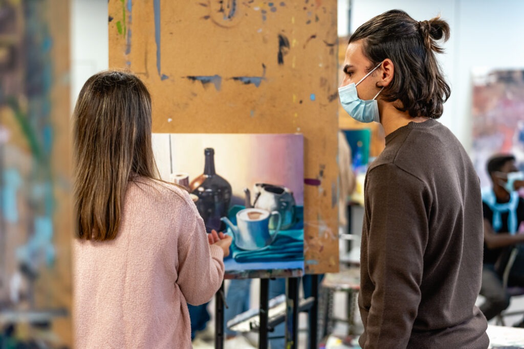 Young students wearing face mask during lesson in faculty of arts university