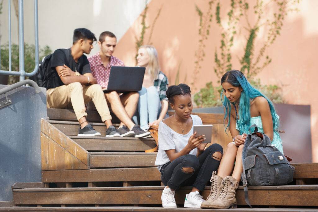 The students stairs. Shot of a group of young students enjoying a break outdoors on campus.