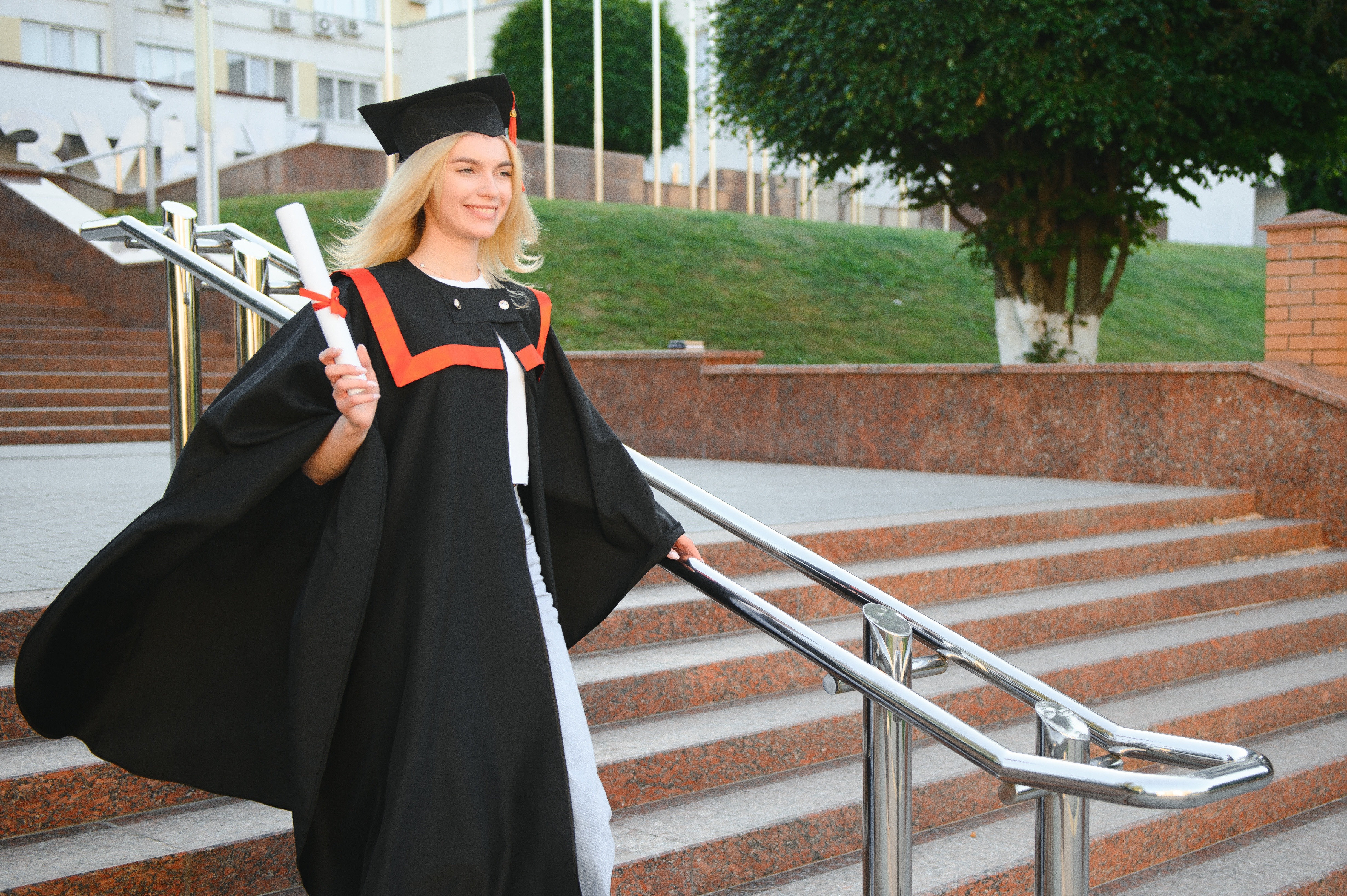 A young female graduate against the background of university.