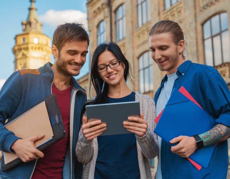 a-group-of-young-multi-ethnic-group-of-student-in-university-smiling-and-looking-at-the-tablet.jpg